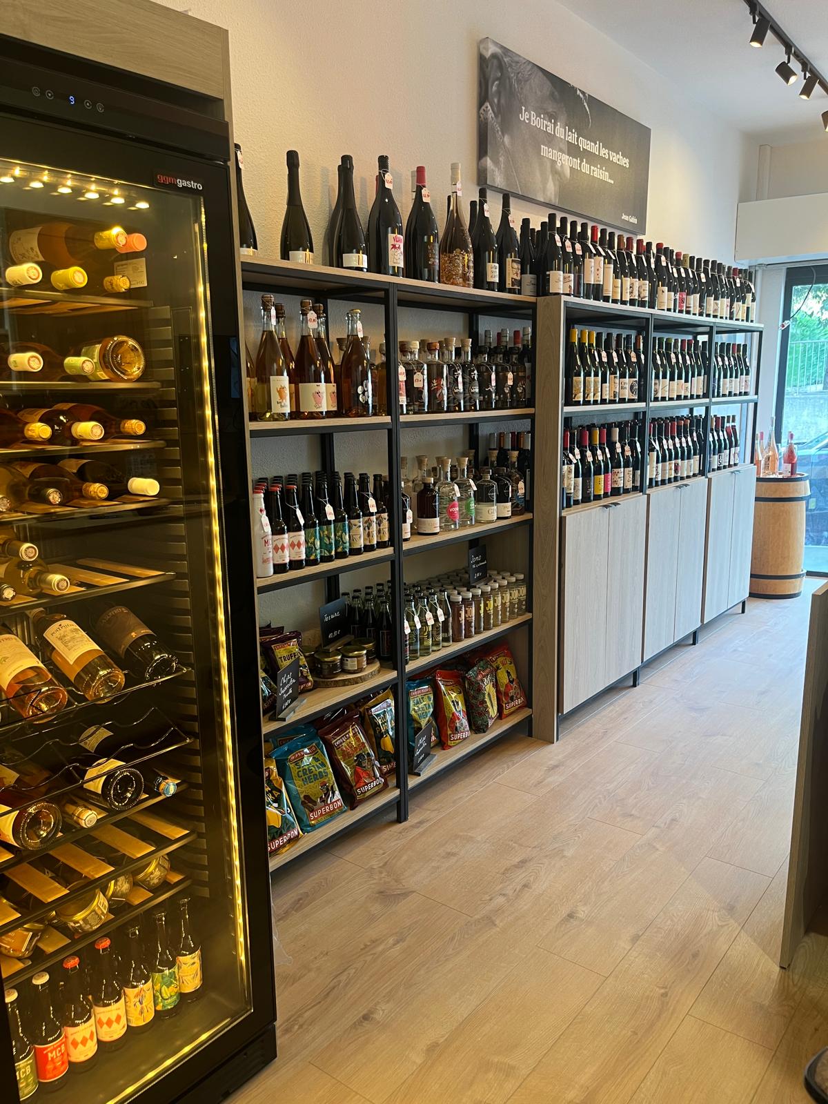 Intérieur de la Cave Glouglou à Nice Ouest avec rayonnages remplis de bouteilles de vin, spiritueux et bières artisanales